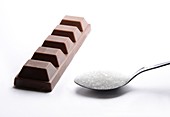 Teaspoon of sugar with bar of chocolate