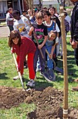 Children planting a tree for Earth day