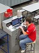 Worker using laptop in a factory