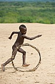 Young Karo boy with home made toy hoop