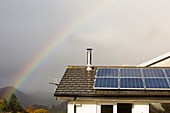 Rainbow over a house with solar panels