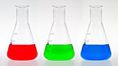 3 conical flasks holding coloured liquids