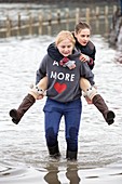 Children wade through flood waters