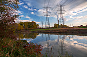 Electricity pylons by a lake