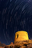 Star trails over ancient watchtower,Iran