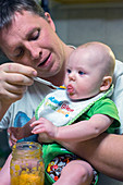 Man feeding a baby
