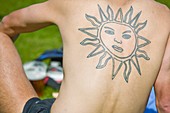 Man with a sun symbol tattoo on his back