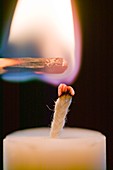 Lighting a candle with a match