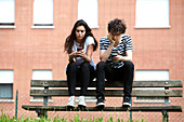 Teenage couple using smart phones
