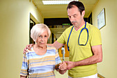 Hospital doctor assisting elderly woman