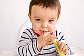 Baby boy playing with a spoon