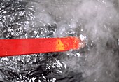Red-hot metal being quenched in water