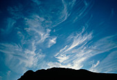 Cirrus clouds over mountain ridge