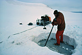 B.A.S/ scientist chainsawing hole in ice