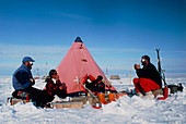 Antarctic research team relaxing outside tent