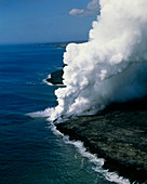 Steam rising as molten lava meets the ocean