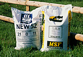 View of two bags of NPK fertiliser by a fence