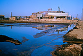 Polluted water and mud flats near a factory