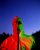 Worker in a chemical spillage suit with a gas mask