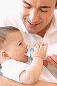 Father bottle-feeding baby girl