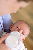 Mother bottle-feeding baby boy