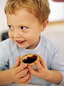 Boy eating a jam tart
