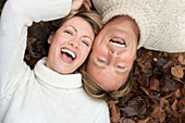 Laughing couple lying on autumn leaves