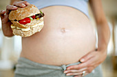 Pregnant woman with a sandwich