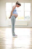 Pregnant woman weighing herself