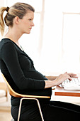 Pregnant woman typing