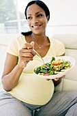 Pregnant woman eating a salad