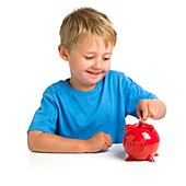 Boy putting money in a piggy bank