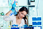 Young woman using pipette