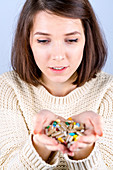 Young woman with capsules in her hands