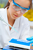 Lab assistant using a pipette