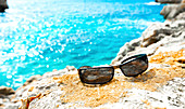 Sunglasses on the rocks by the sea