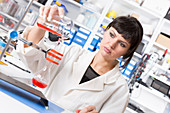 Lab assistant pouring liquid in lab