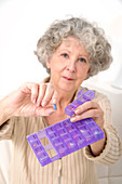 Woman holding pill and pill container