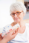 Woman looking at pill container