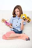 Girl playing with doll and toy truck