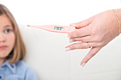Person holding a digital thermometer