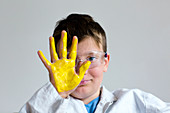 Boy with yellow paint on hand