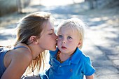 Girl kissing brother on cheek