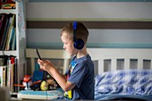 Boy wearing headphones using device