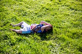 Young boy lying on grass