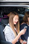 Girl using smartphone in car