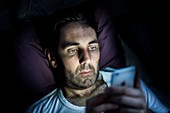 Man using smartphone in dark