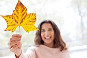 Woman holding an autumn leaf