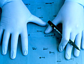 Hands marking bacterial colony autoradiograph