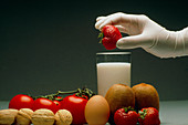 Gloved hand with food that can cause allergies